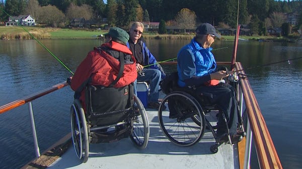peer over lake with men fishing from wheelchairs