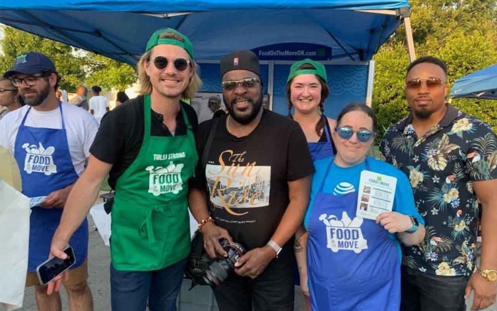 A photographer poses for a picture with volunteers