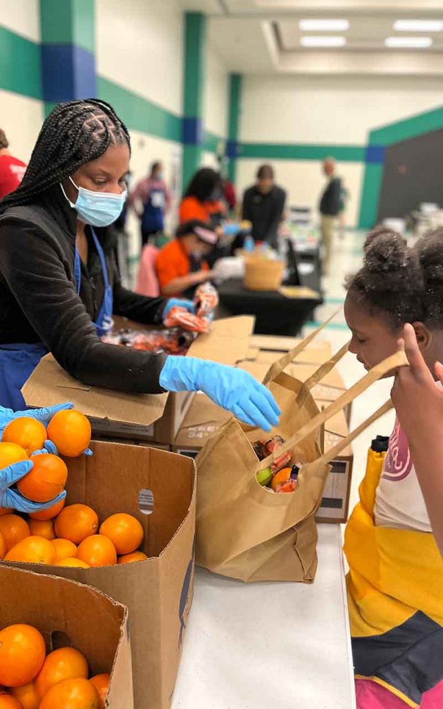 Young girl looking into bag of fruit