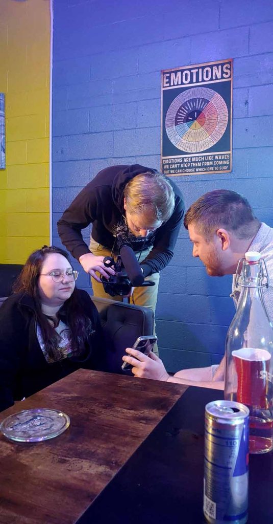 Sloppy McCoy and Bradley McPherson sit at a table being filmed