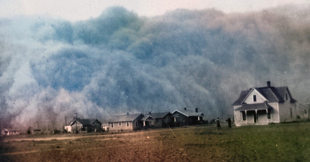 Old image of dust bowl storm hitting a town - colorized