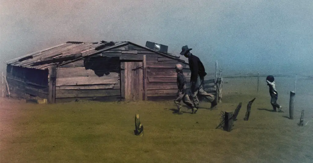 Man and child walking by a short wooden home - colorized