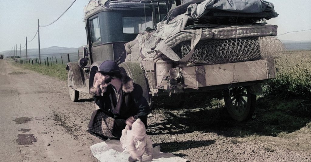 Old image of car on the side of road during 1930s. A woman with a child is near the car. - colorized